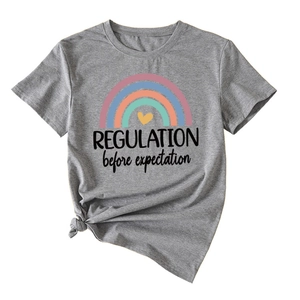 Detail of grey t-shirt showing rainbow print and stylish knotted hem detail