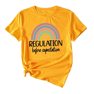 Detail of rainbow graphic and text on mustard yellow t-shirt with knotted hem