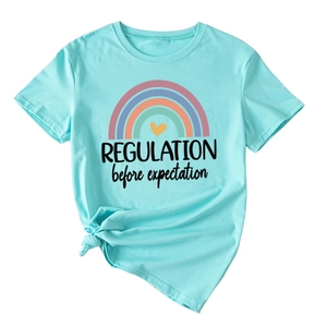 Detail of light blue T-shirt featuring rainbow print and REGULATION before text with knot
