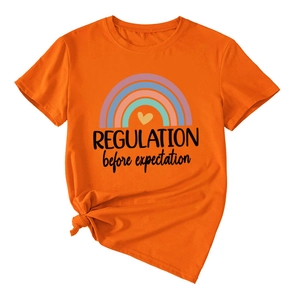 Close-up of orange cotton t-shirt with rainbow print and 'REGULATION before expectation' text