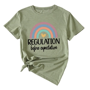 Detail of sage green T-shirt with rainbow graphic and REGULATION before expectation slogan