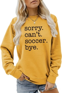 Close-up of sorry can't soccer bye lettering on yellow long sleeve sweatshirt