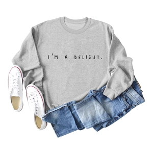 Flat-lay detail of light grey I'M A DELIGHT sweatshirt with denim shorts and sneakers
