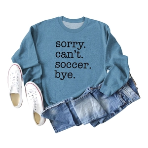 Flat lay of light blue soccer printed sweatshirt with denim shorts and white shoes