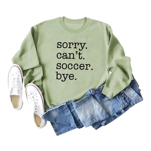 Green soccer print sweatshirt paired with blue jeans and white sneakers flat lay