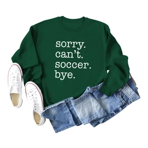 Flat lay of green 'Sorry Can't Soccer Bye' sweatshirt with jeans and sneakers