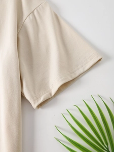 Detail view of double-stitched sleeves and breathable cotton texture on beige t-shirt