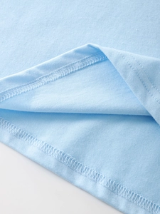 Detail view of double-needle hem stitching and overlock finish on light blue cotton T-shirt