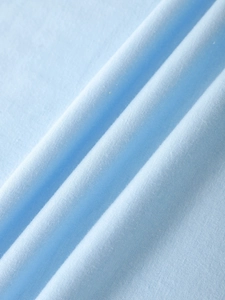 Close-up of premium light blue knitted cotton fabric showing soft texture and fine grain
