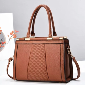 Brown quilted diamond stitch tote bag in pebbled leather with gold hardware and shoulder strap