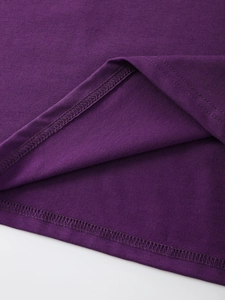 Detailed close-up of double-stitched hem and fabric texture on dark purple t-shirt