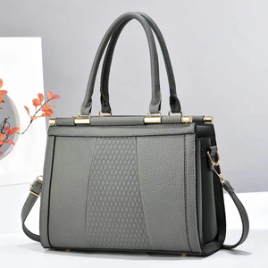Detail of grey quilted handbag showing textured scale pattern and gold hardware