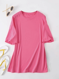 Flat lay of pink loose round neck t-shirt with summer flip-flops and sunglasses