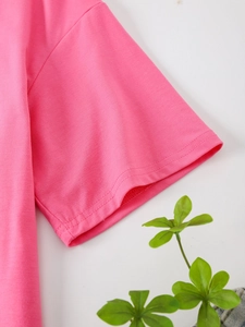 Detail of pink cotton T-shirt showing high-quality double-needle stitching on cuff and shoulder