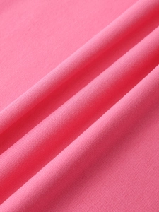 Macro shot of bright pink knit fabric texture with fine ribbed weave and soft draping