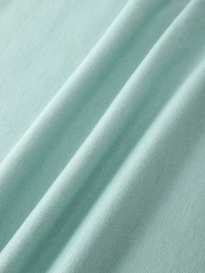 Macro shot of mint green ribbed knit fabric showing soft texture and elastic weave