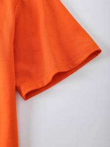 Detail of the high-quality double-needle stitching on the orange knit T-shirt sleeve cuff