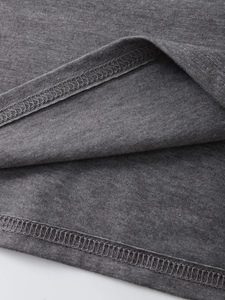 Close-up of dark grey T-shirt fabric with durable double-stitched hem and flat lock seams