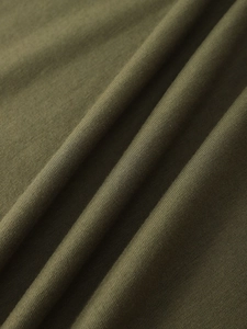 Close-up of olive green knitted fabric showing fine texture and soft cotton material