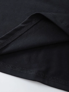 Close-up of double-needle stitching on the hem of a black cotton women's t-shirt