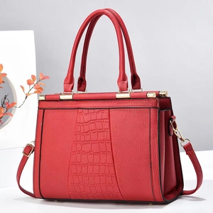Detail of red tote bag with stone pattern patchwork and elegant golden hardware