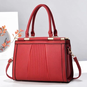 Detail of red lychee leather tote bag featuring pleated texture and gold hardware