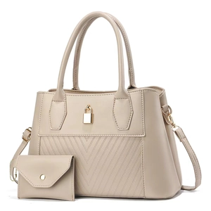 Detail of beige quilted tote bag with golden lock and matching envelope pouch