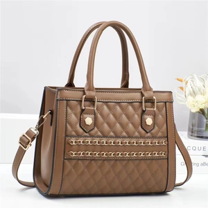 Detail of brown quilted bag with gold chain accents and adjustable crossbody strap
