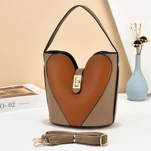 Detail of two-tone bucket bag with heart patch and golden metal twist lock closure