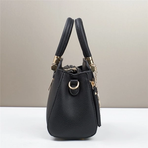 Side view showing black lychee texture leather handbag with gold metal hardware details