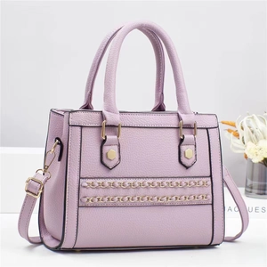Close-up of lavender faux leather handbag featuring golden chains and hexagon hardware