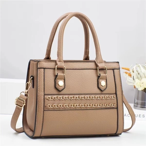 Detail view of khaki pebbled leather shoulder bag with decorative gold chains and hardware