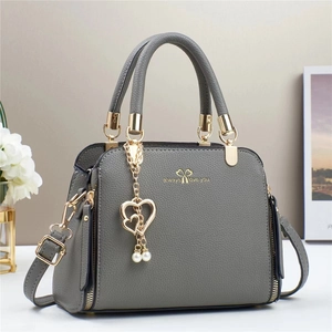 Detail of dark gray lychee texture PU leather handbag with golden heart pearl pendant