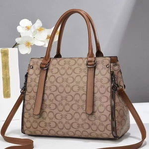 Chic women's monogram print handbag with brown leather handles and crossbody strap
