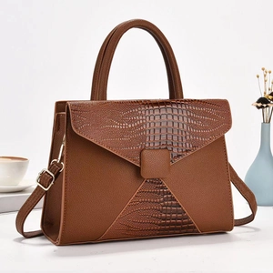 Brown leather crossbody bag with crocodile texture and adjustable strap in a stylish setup