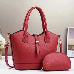 Détail d'un sac seau rouge à motif litchi avec petit porte-monnaie et boucles dorées chic
