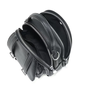 Detail view of mini crossbody bag with three zipper compartments and lychee texture