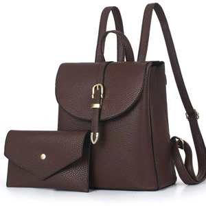 Detail view of dark brown pebbled leather backpack set with gold metal hardware and pouch