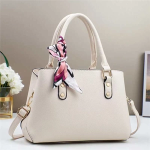 Beige pebbled leather tote bag with decorative silk scarf and gold hardware accents