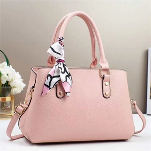 Pink lychee texture tote bag with a decorative floral silk scarf on a white surface