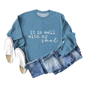 Flat lay of blue long sleeve sweatshirt with it is well with my soul script text