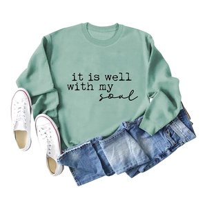 Flat lay of sage green crewneck sweatshirt with It is Well with My Soul print and shorts