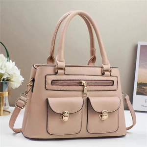 Detail view of pink lychee leather handbag featuring gold hardware and utility pockets
