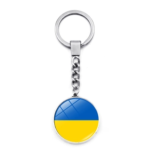 Detail of round metal keychain featuring double-sided Ukraine flag glass pendant