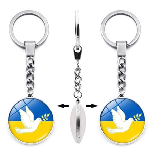 Ukraine flag keychain featuring a peace dove on a double-sided glass dome pendant