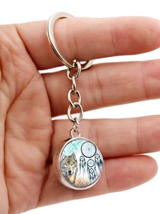 Close-up of double-sided glass dome wolf dreamcatcher keychain with silver metal finish