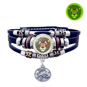Close-up of leather zodiac bracelet featuring Leo lion charm and green luminous effect