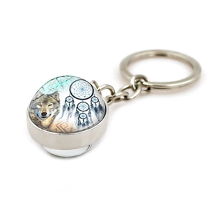 Detailed close-up of a dreamcatcher wolf glass ball pendant on a silver metal keychain