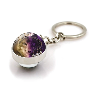 Detail of dreamcatcher wolf keychain with a double-sided glass ball pendant on white background