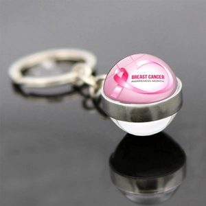 Detail of pink ribbon keychain with Breast Cancer Awareness Month text on dark mirror